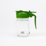 A green glass server bottle with a polypropylene and stainless steel lid, featuring a lever-style pouring mechanism.